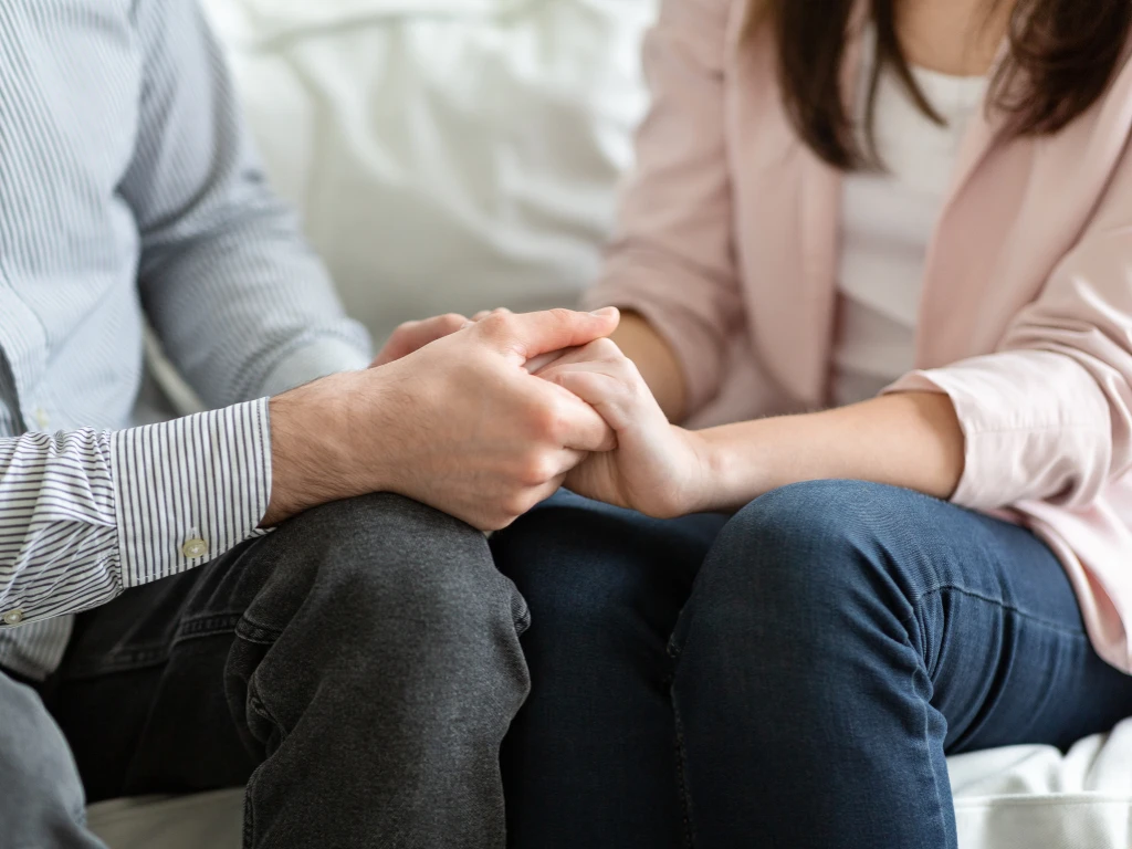 Couple holding hands, showing intimacy.