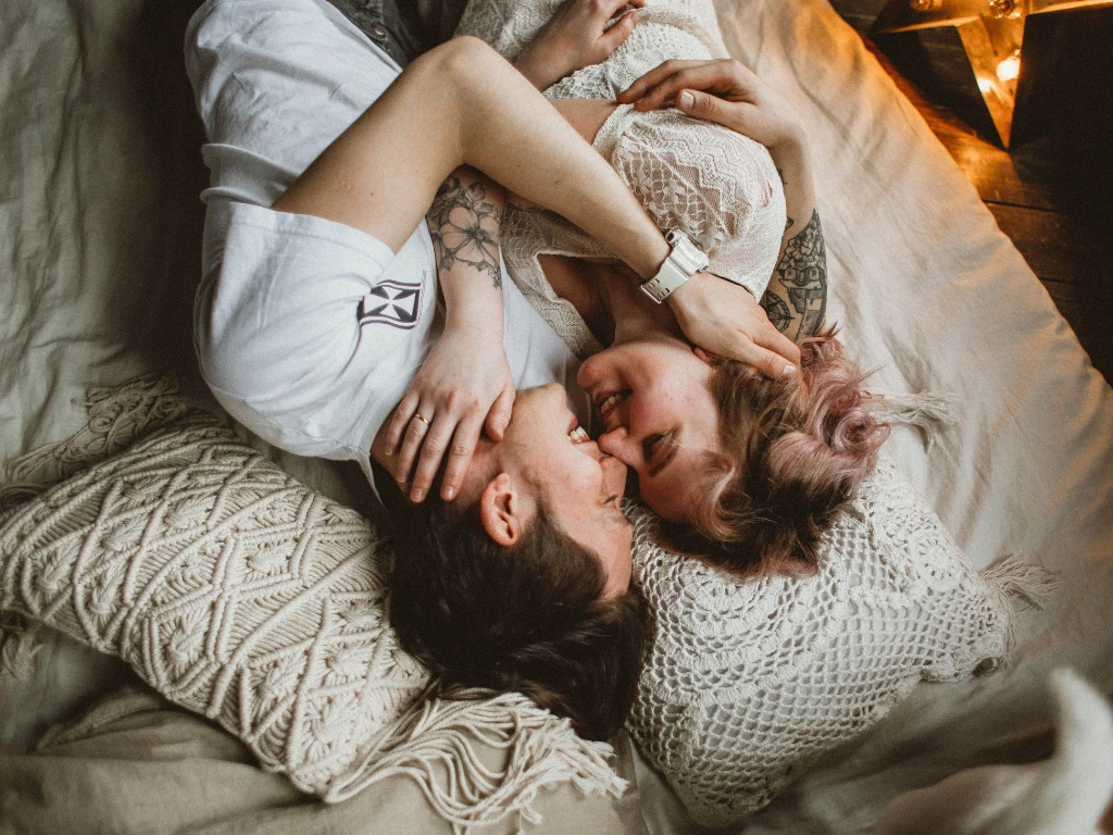 couple smiling holding each other in bed